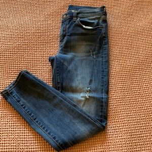 Medium wash skinny jeans with a few holes